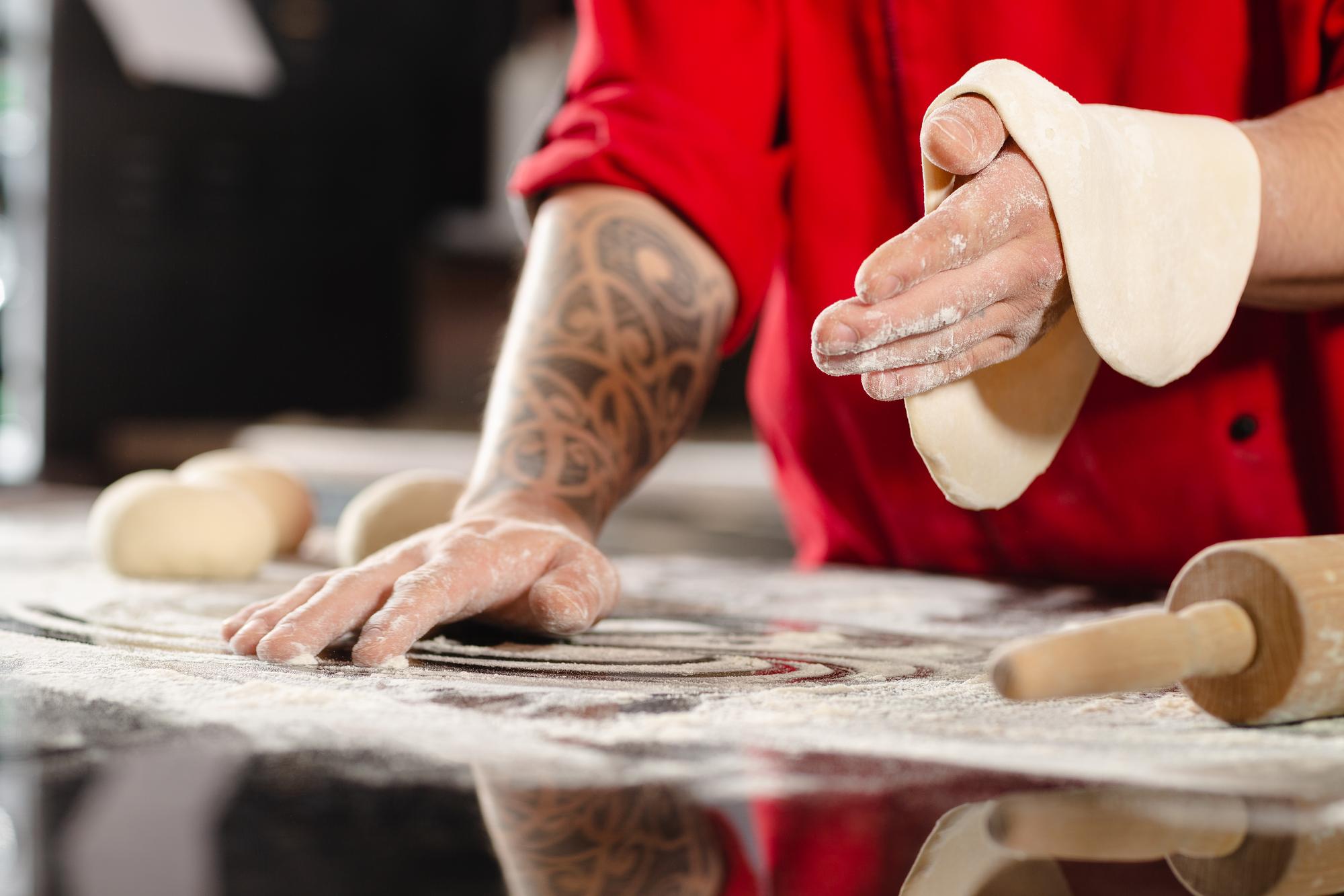 Hands kneading dough on marble